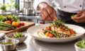 Chef plating a colorful entrée in a professional teaching kitchen.